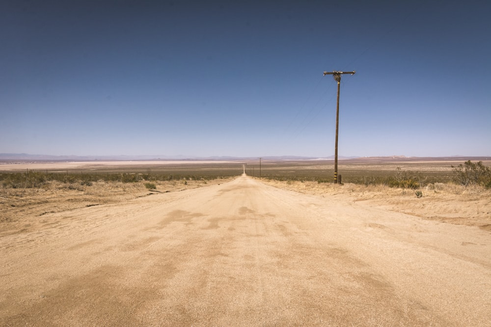 gray metal post on brown sand under blue sky during daytime