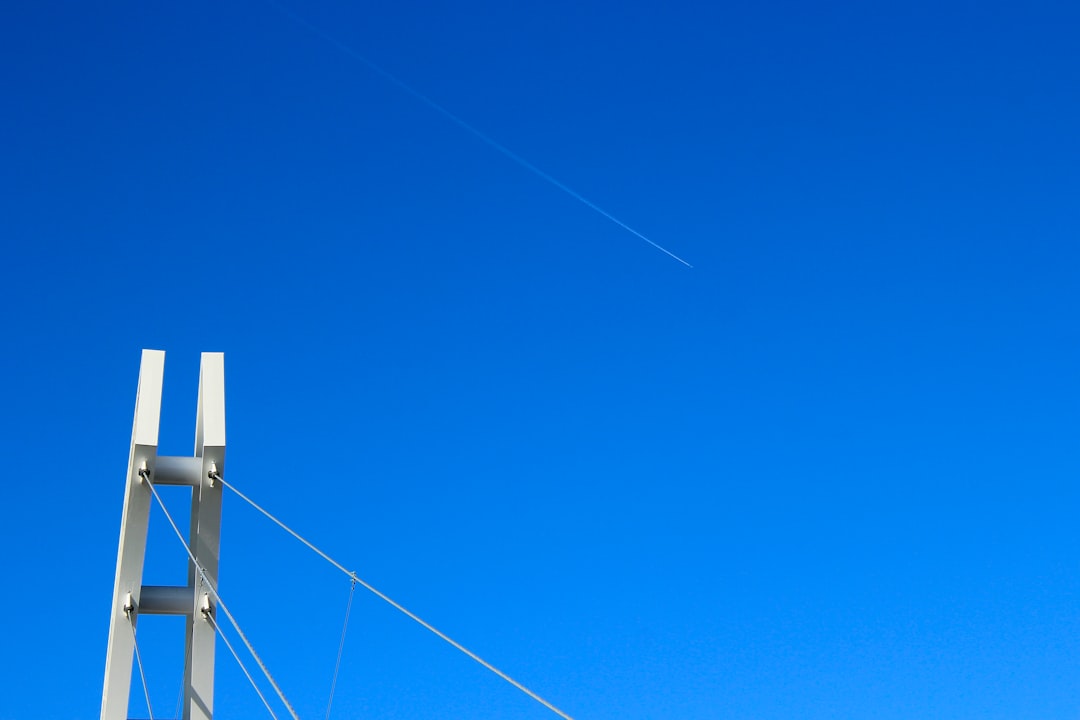 white and blue electric post under blue sky during daytime