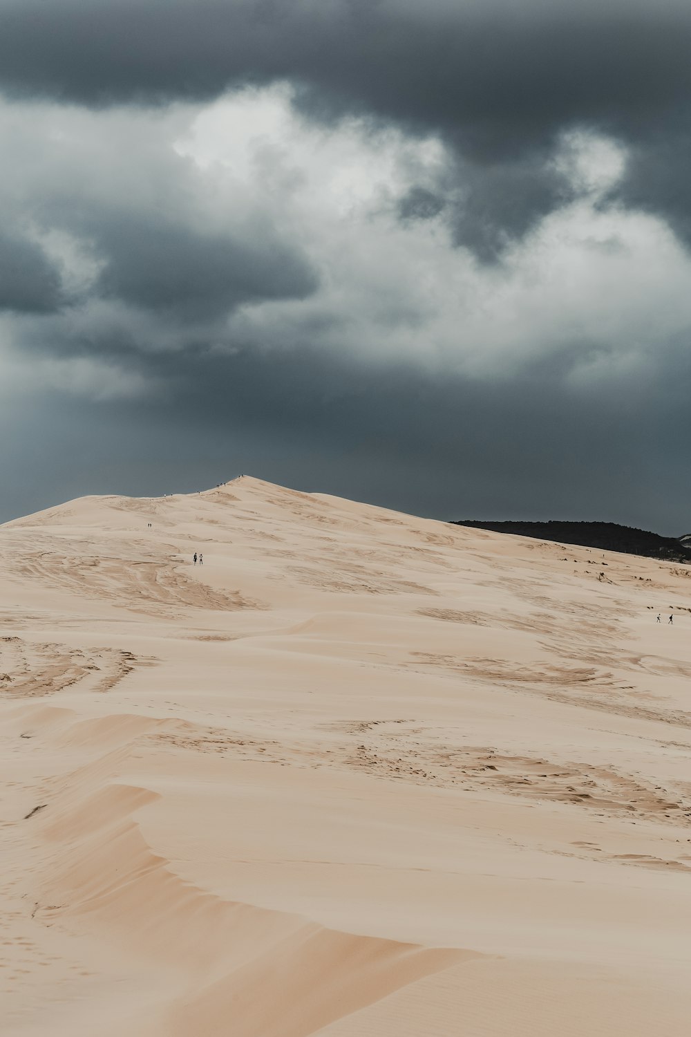 brown sand under white clouds during daytime