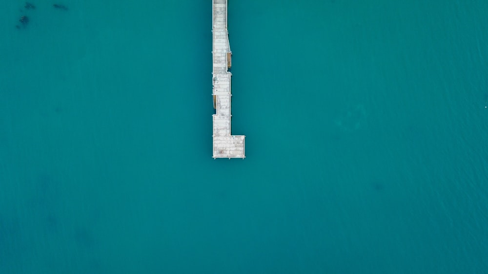 white and brown wooden dock on blue body of water