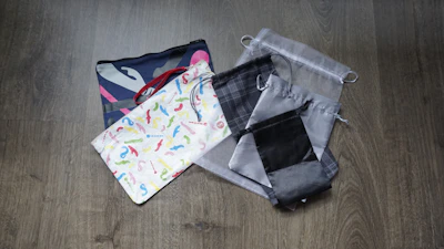 Soft, hand-stitched fabric pouches in various pastel colors laid out on a linen cloth.