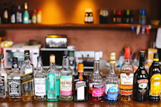 assorted glass bottles on brown wooden table