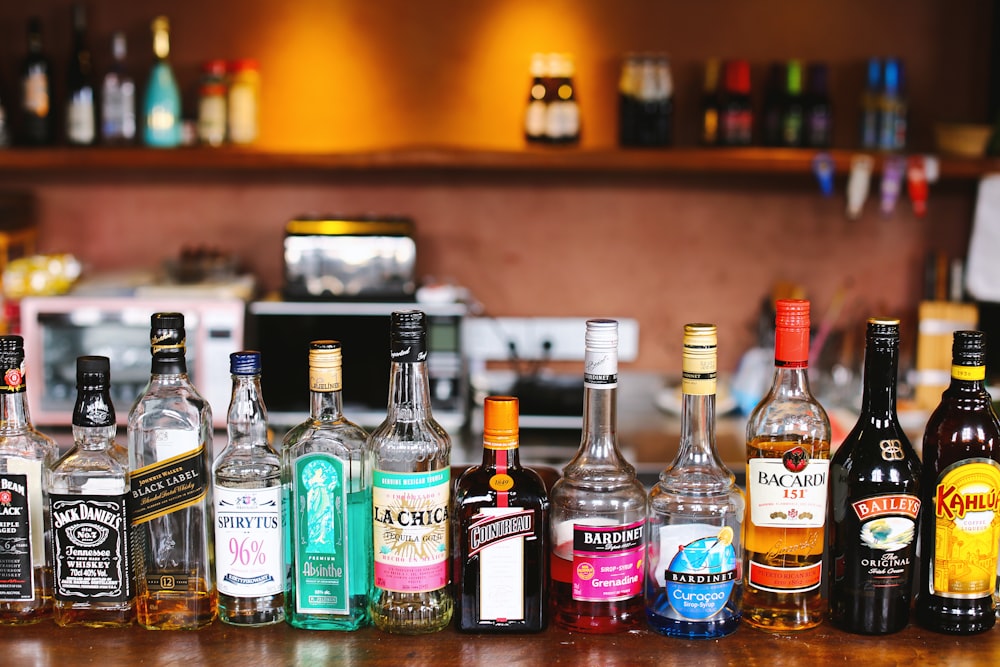 assorted glass bottles on brown wooden table