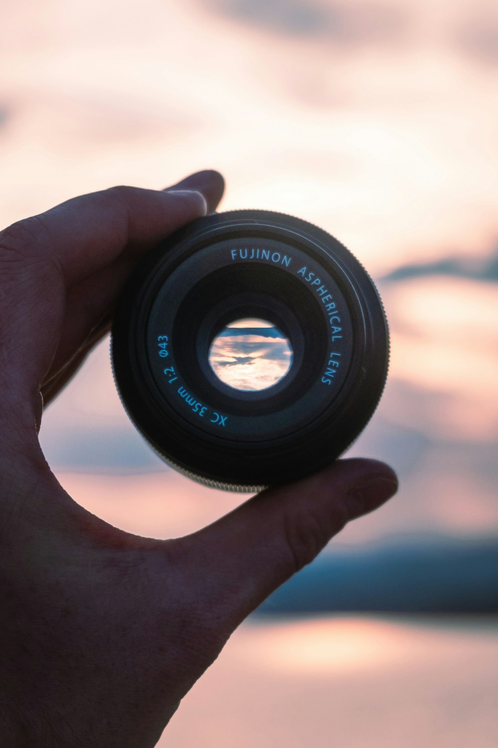 person holding black camera lens