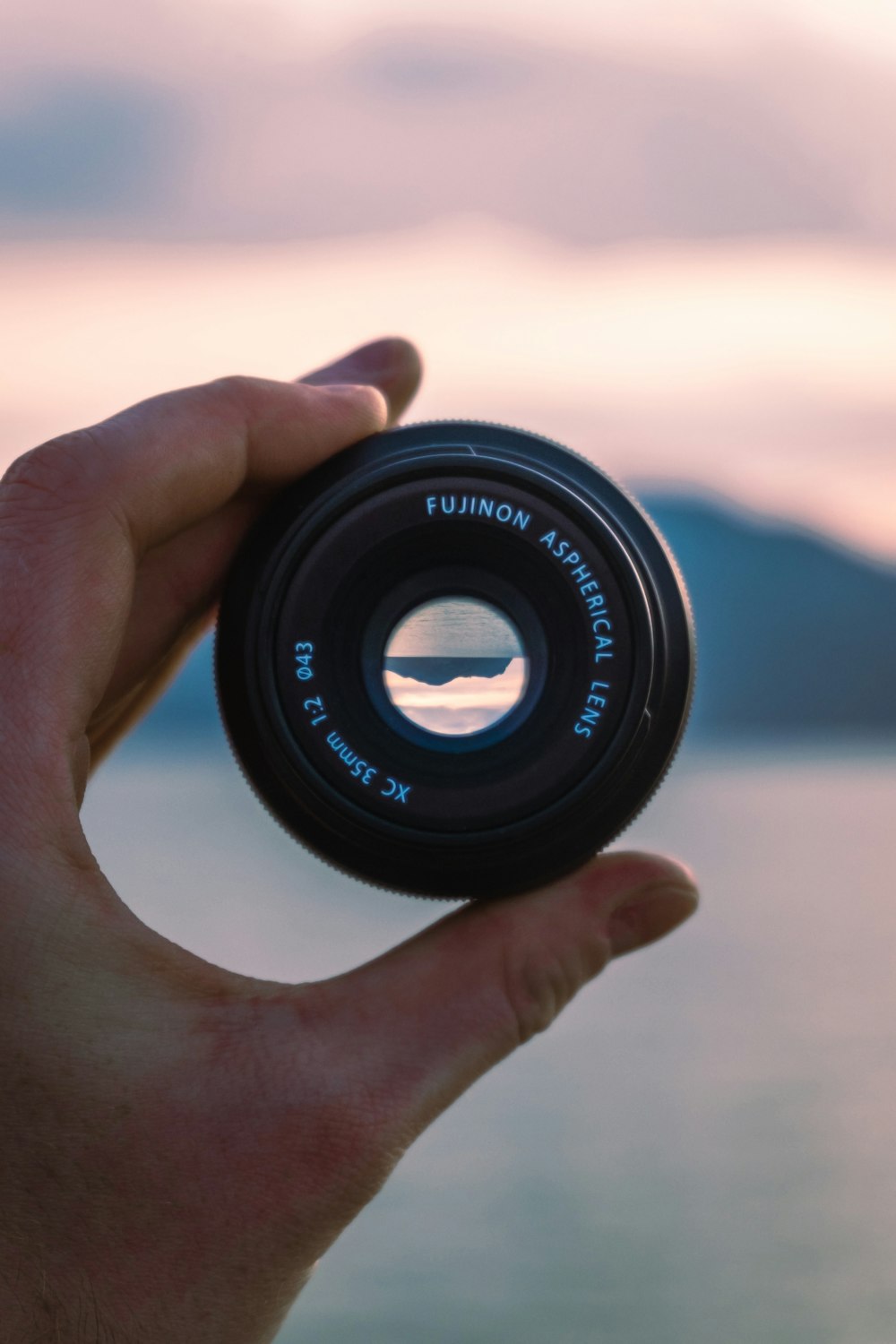 person holding black camera lens