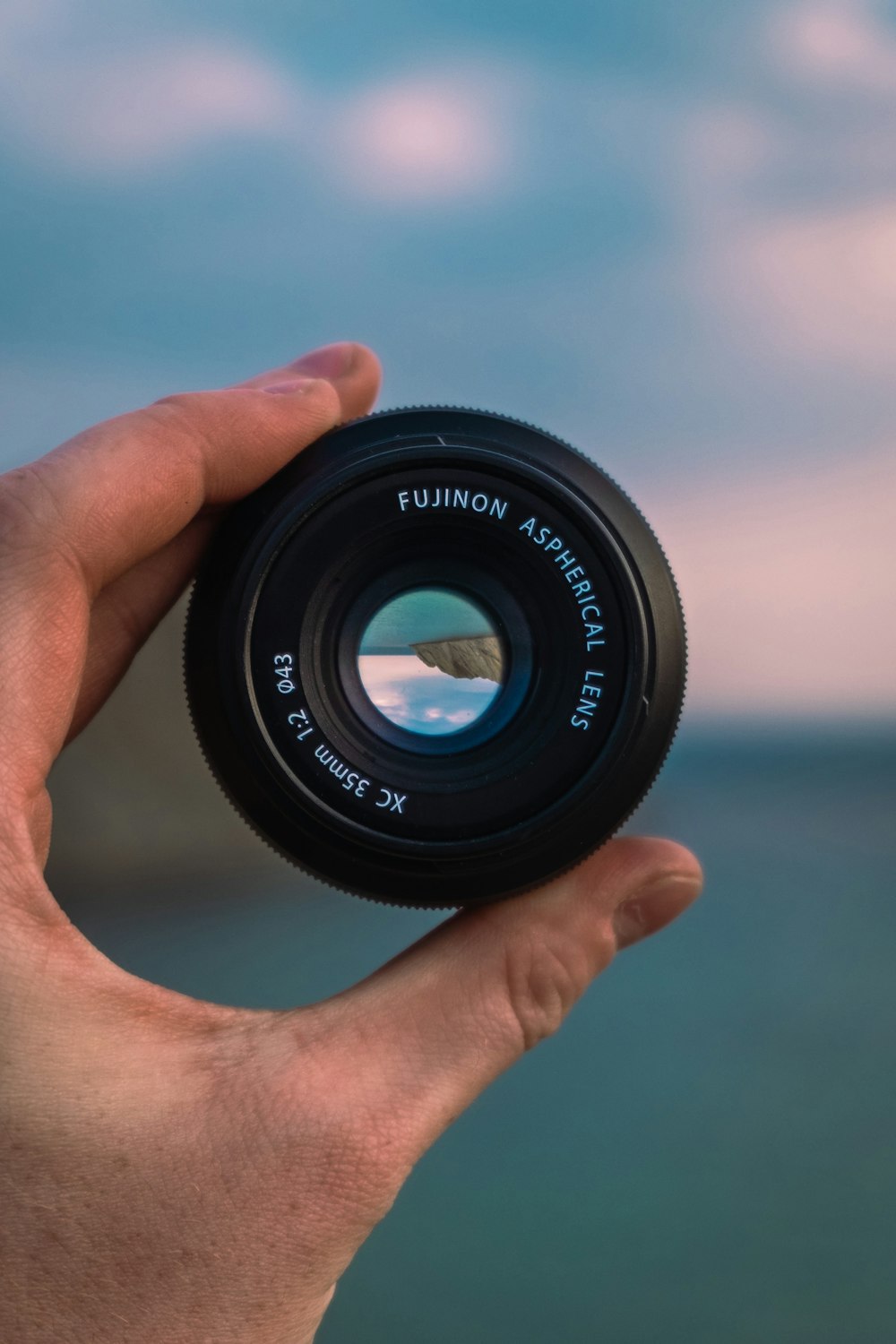 person holding black camera lens