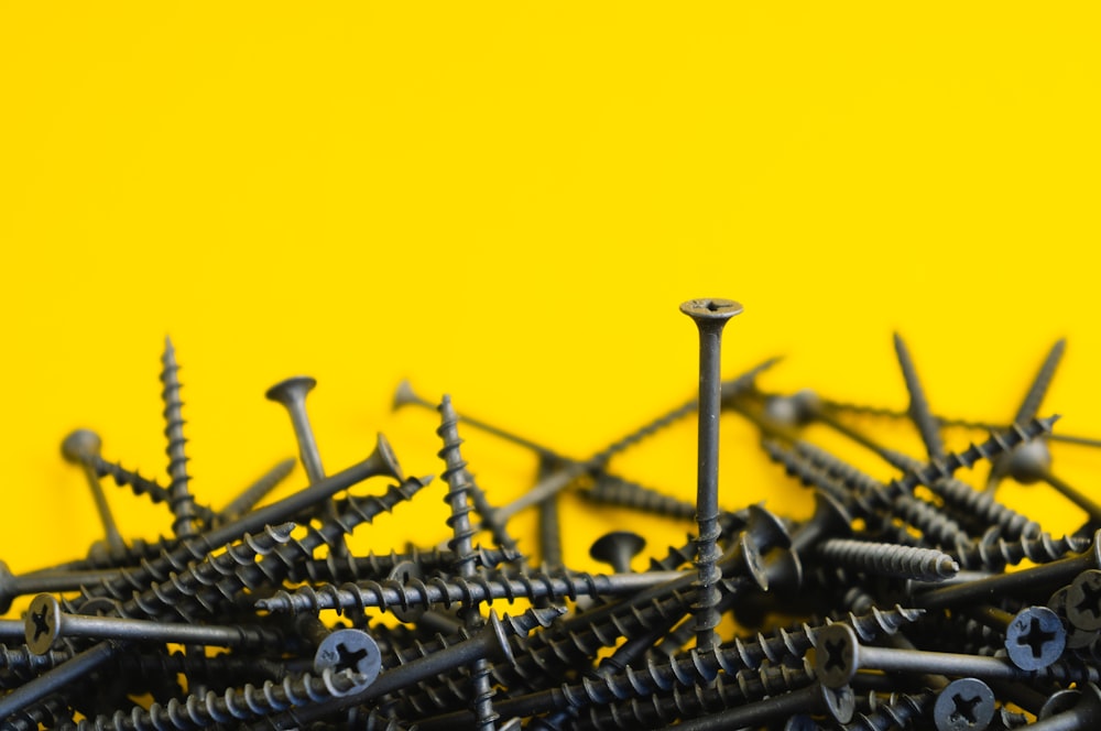 gray metal nails on yellow surface