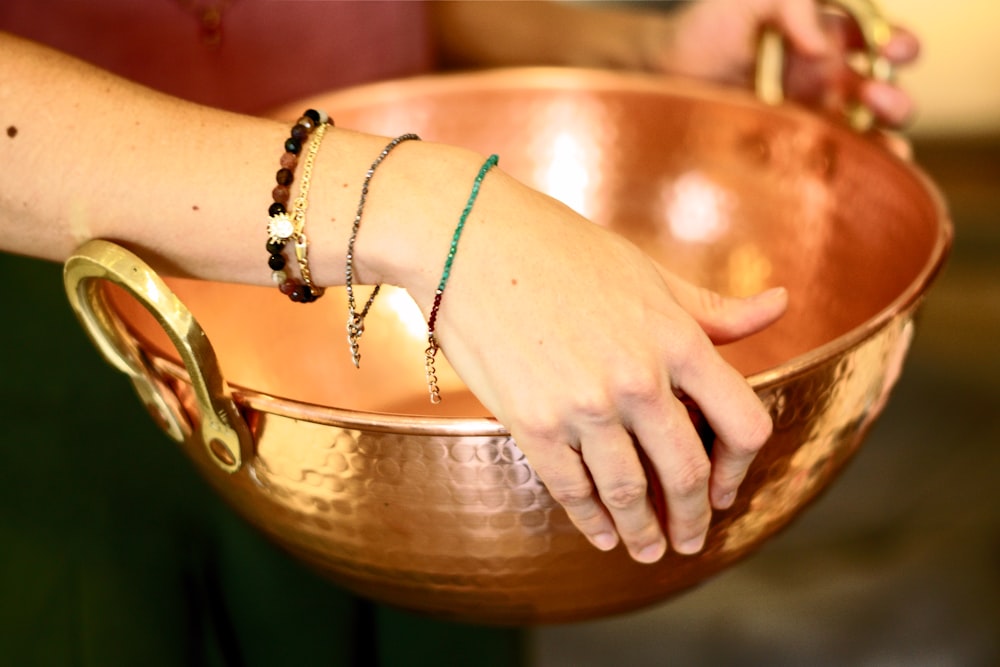 Person mit silbernem Armband und goldenem Armband