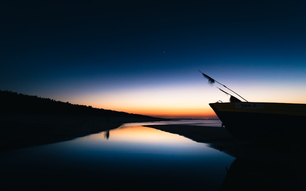 brown boat on water under blue sky during night time