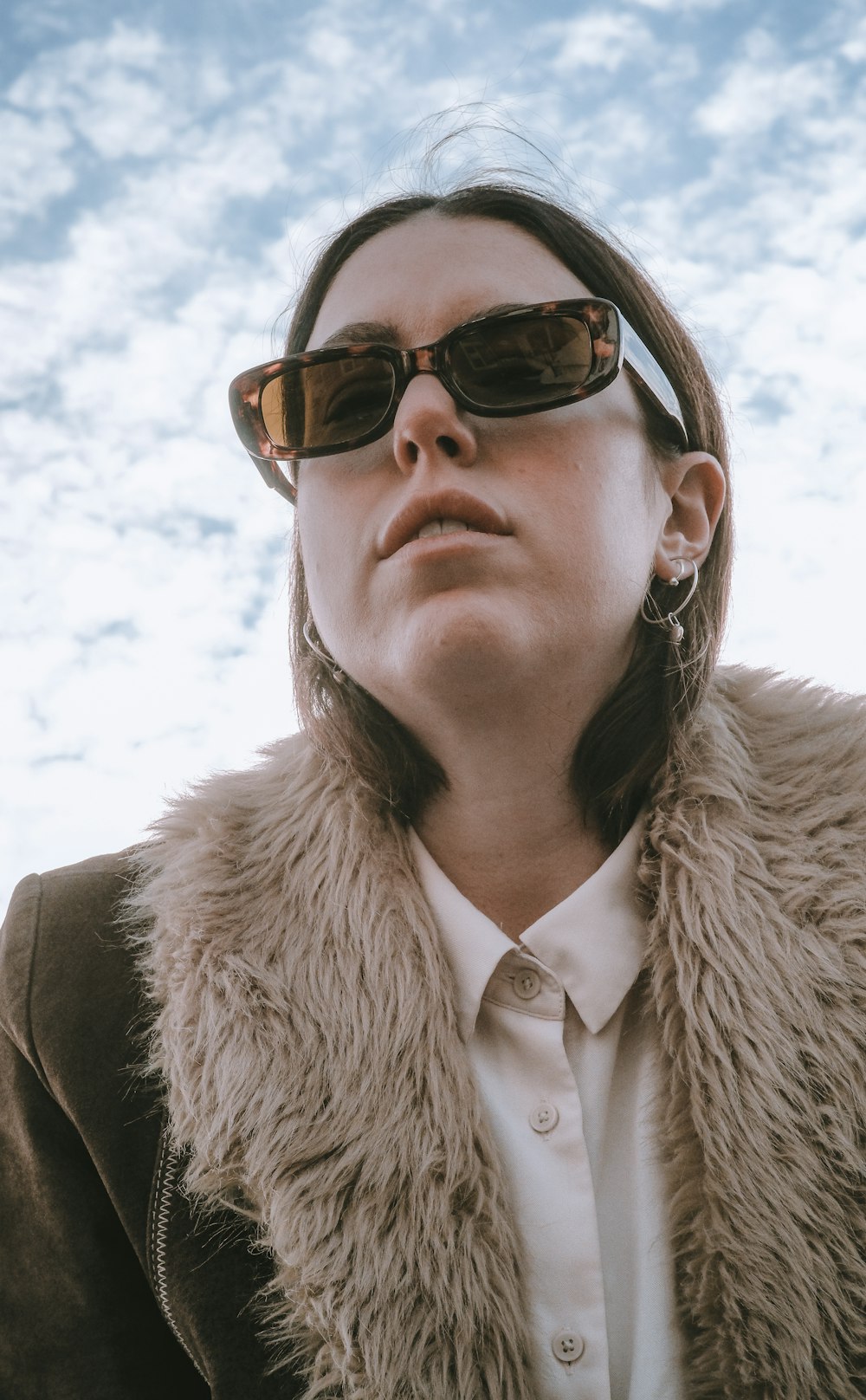 woman in brown fur coat wearing brown sunglasses
