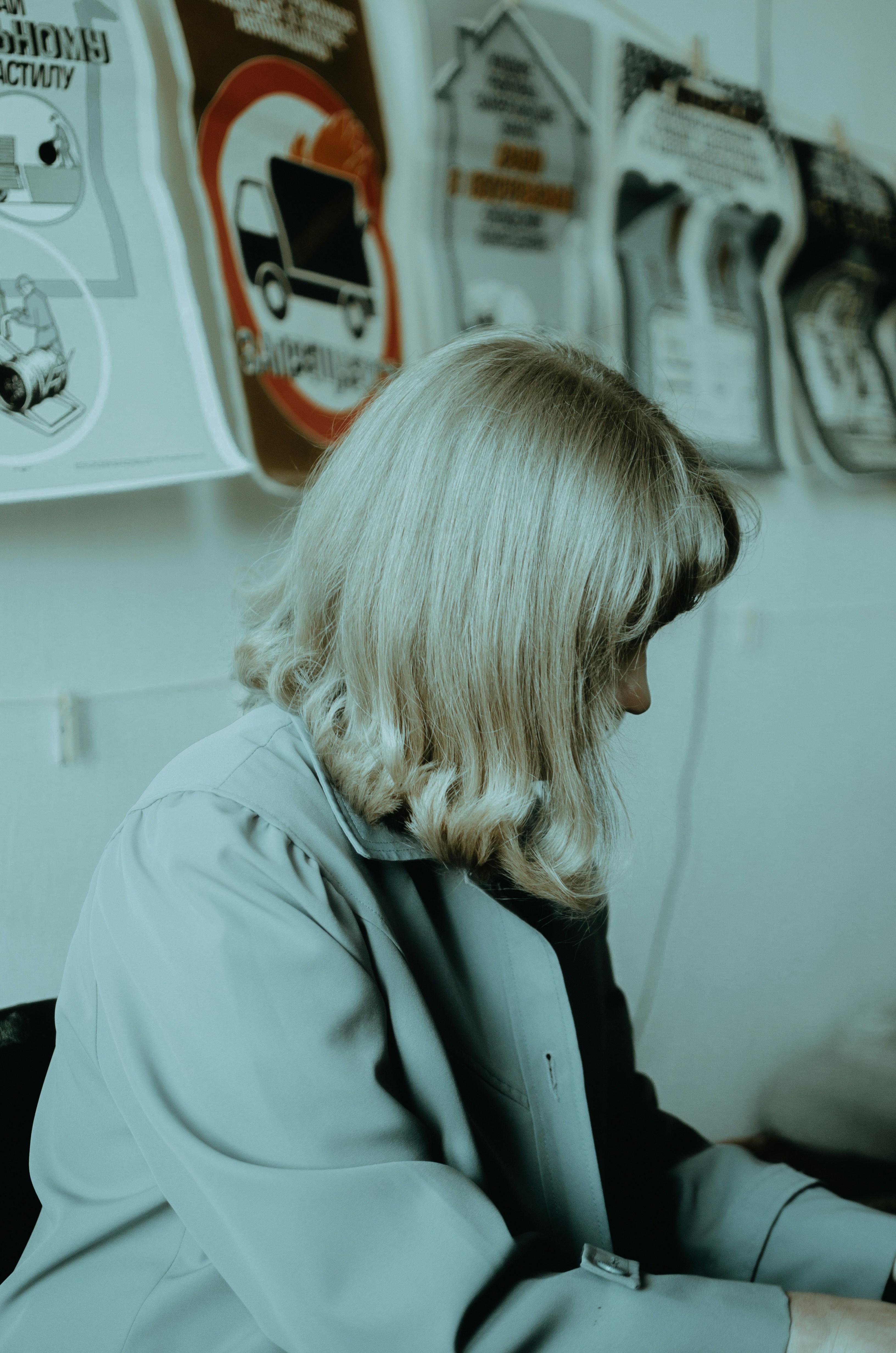 woman in white coat standing near white wall