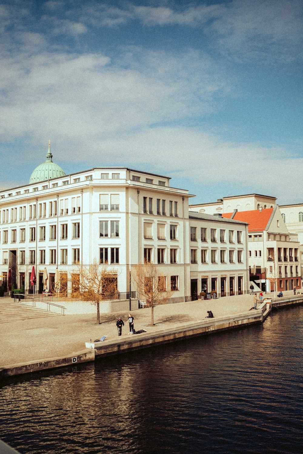 white and brown concrete building near body of water during daytime