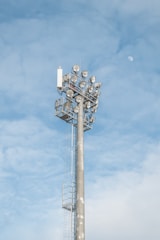 Side view of a solar lighting tower casting bright white light over construction equipment.