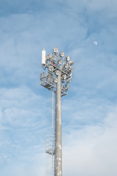 Side view of a solar lighting tower casting bright white light over construction equipment.