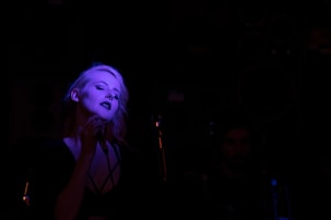 woman in black tank top with blue light on her face