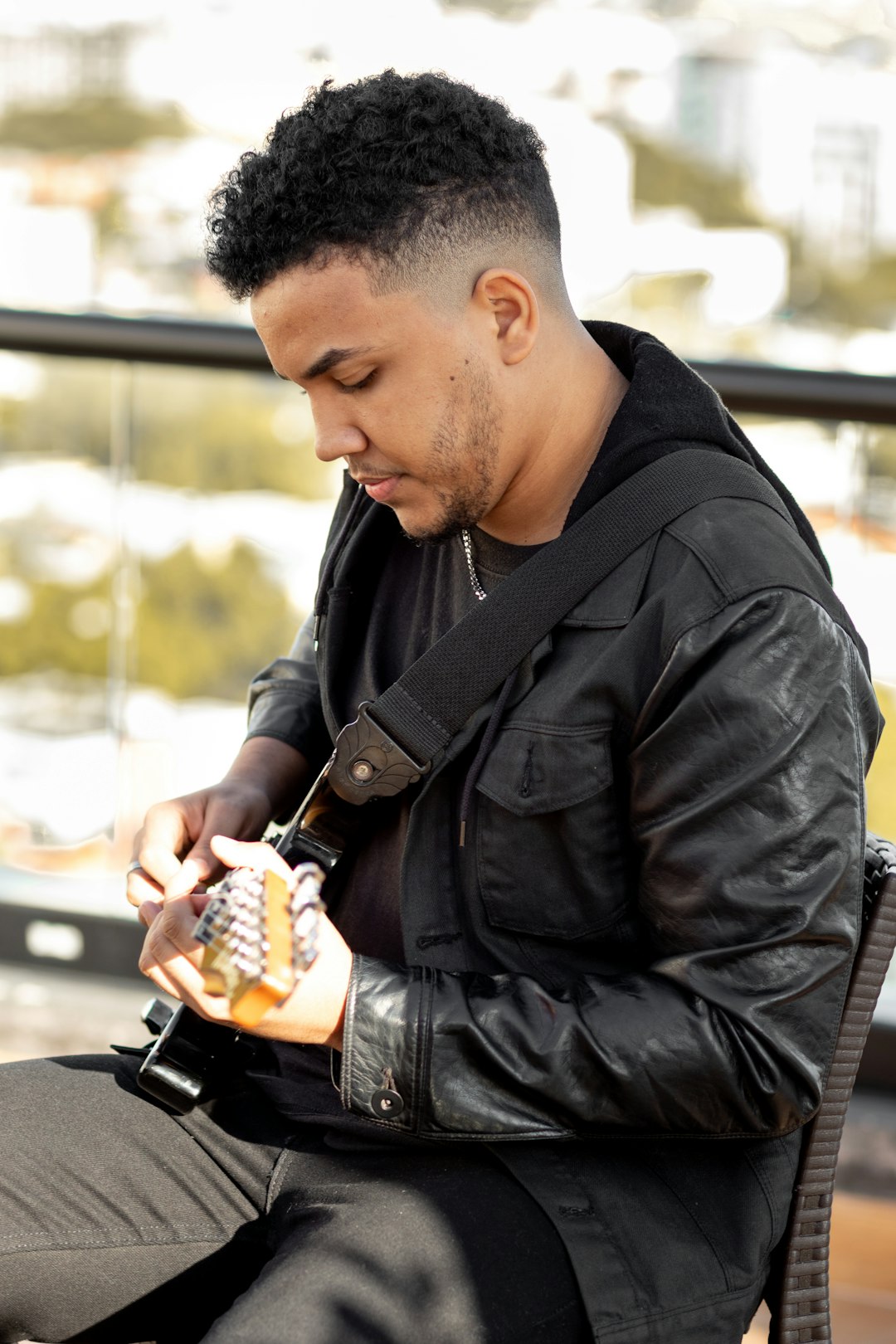 man in black leather jacket holding black smartphone