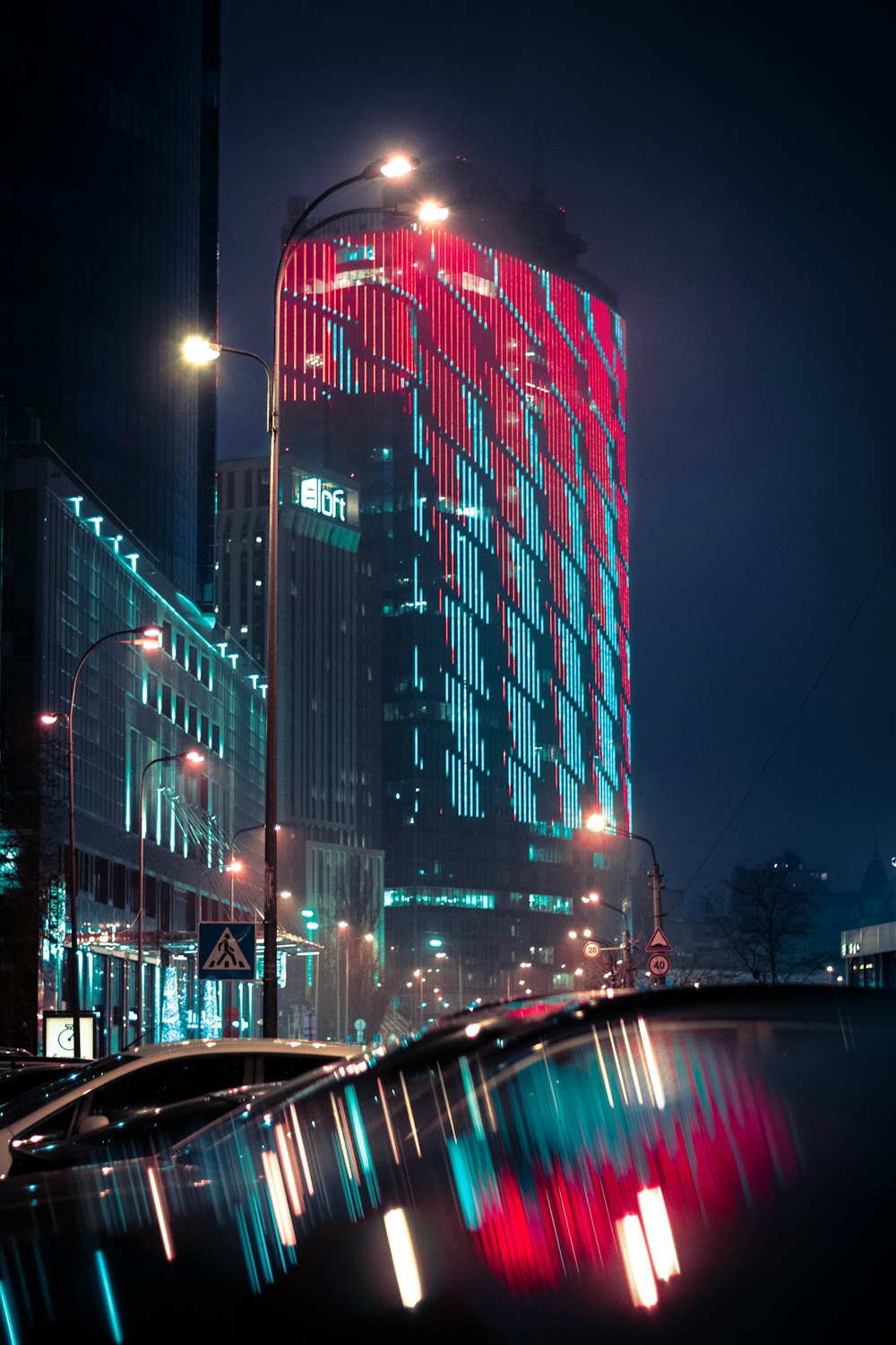 cars on road near high rise building during night time