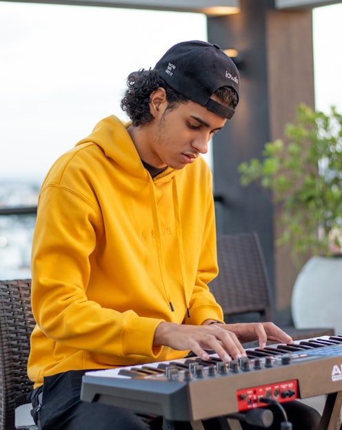 man in yellow sweater using laptop computer