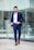 man in blue suit standing on sidewalk during daytime