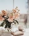 white and pink flowers on white ceramic teacup on white table