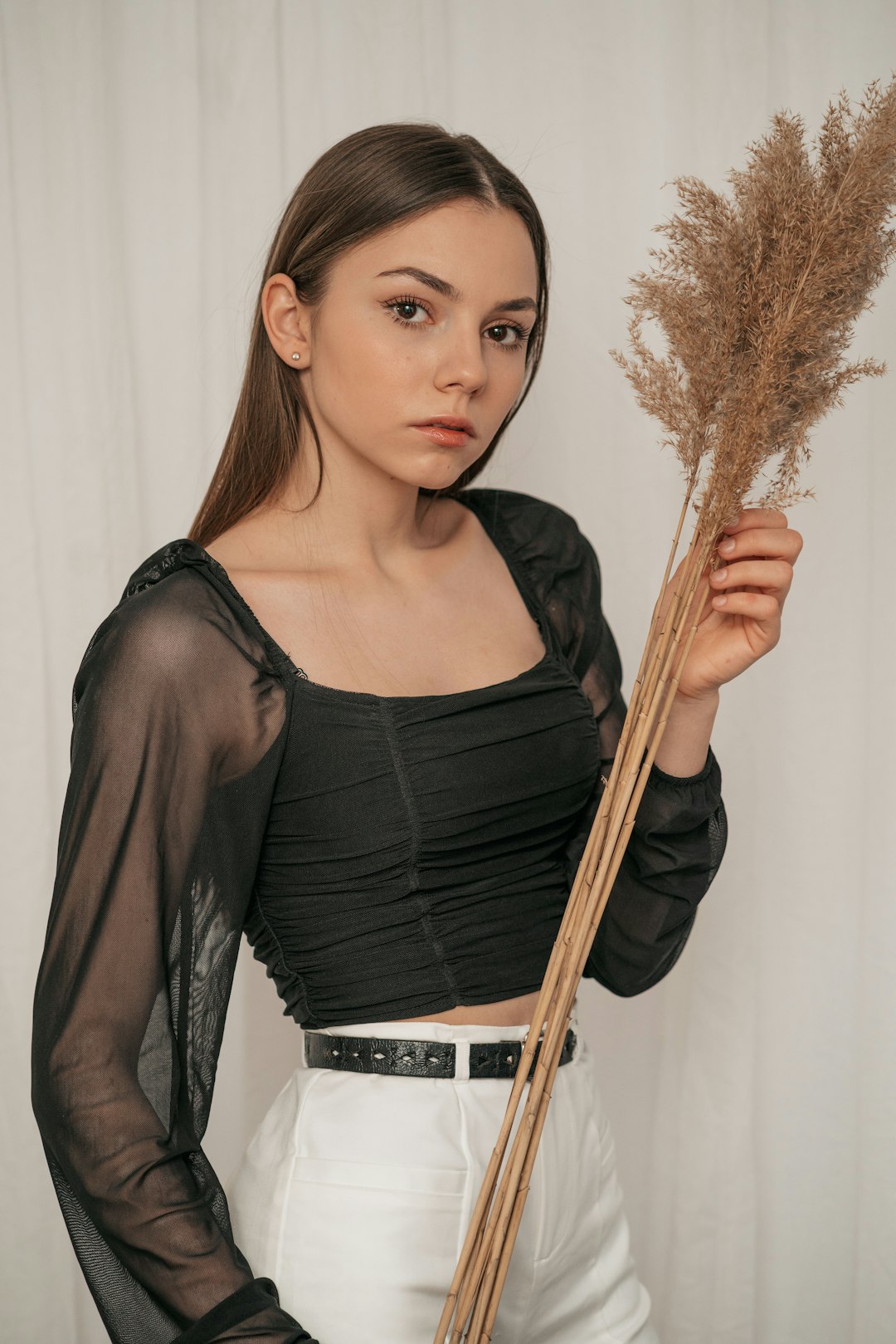 woman in black long sleeve shirt holding brown broom