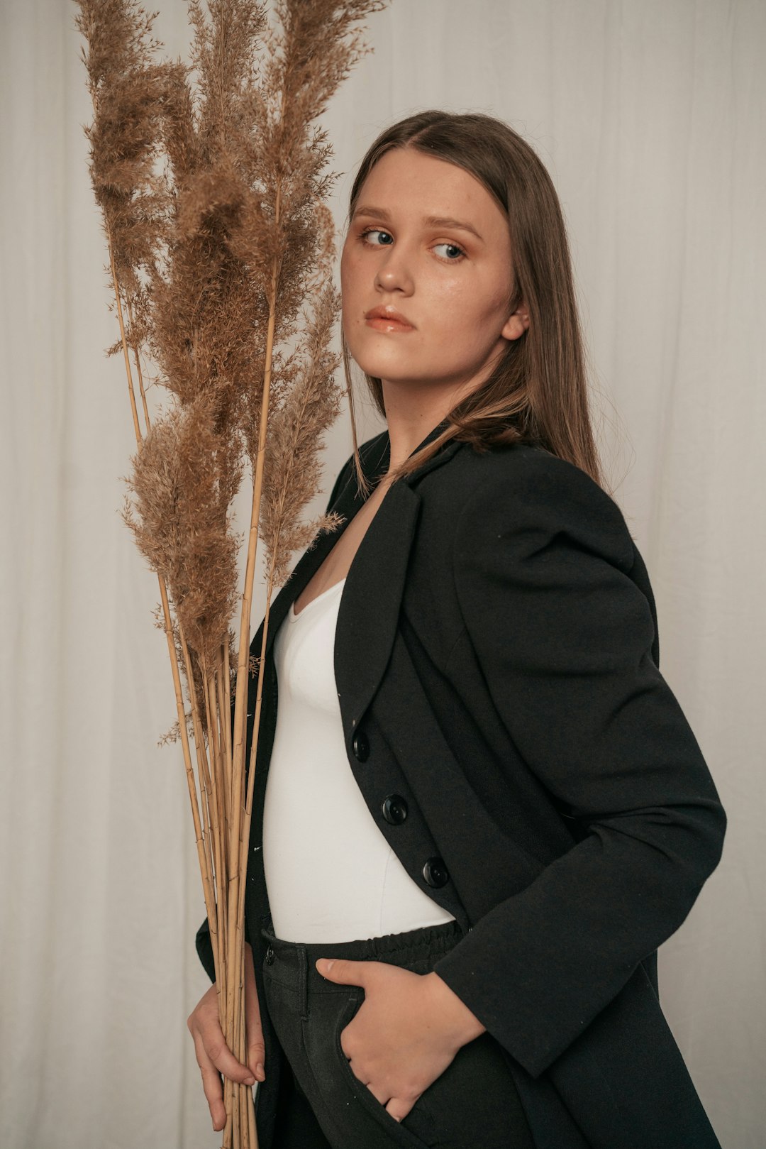 woman in black coat standing near brown plant