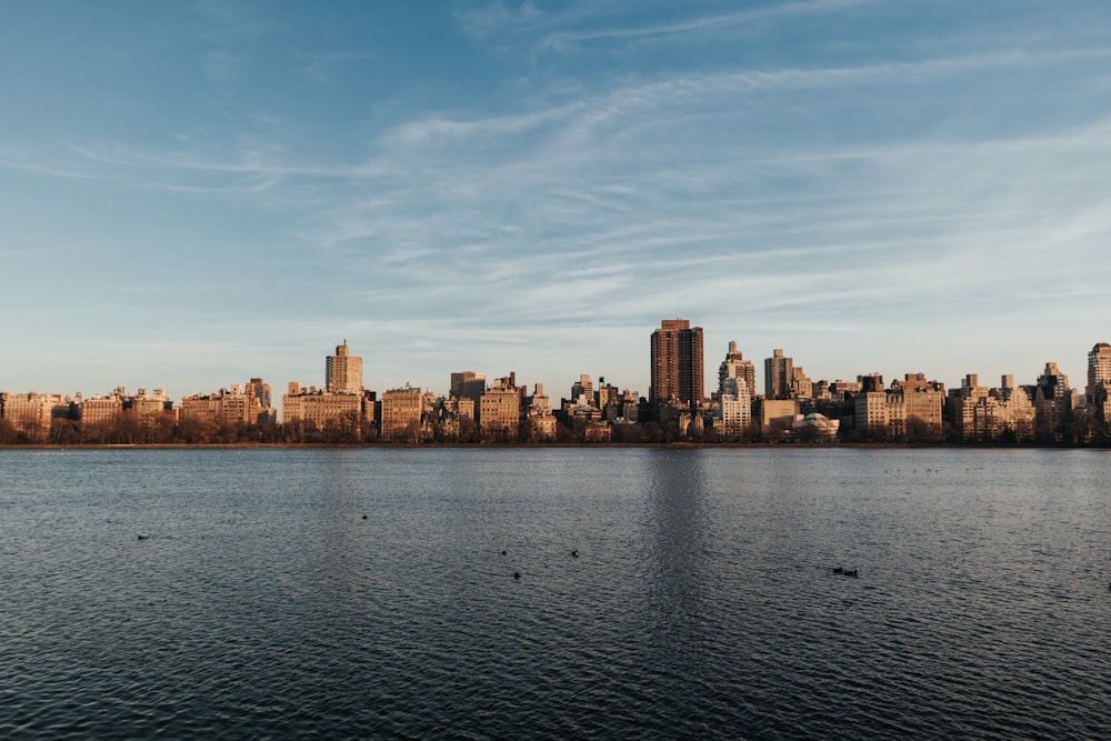 Skyline der Stadt über dem Gewässer unter blau-weißem, sonnigem, bewölktem Himmel tagsüber