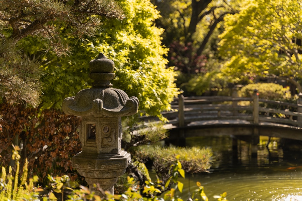 brass colored water fountain near green trees during daytime