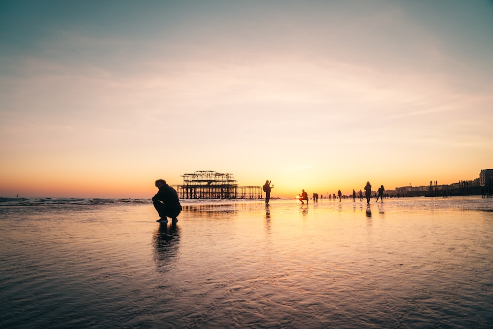 silhouette of people on beach during sunset