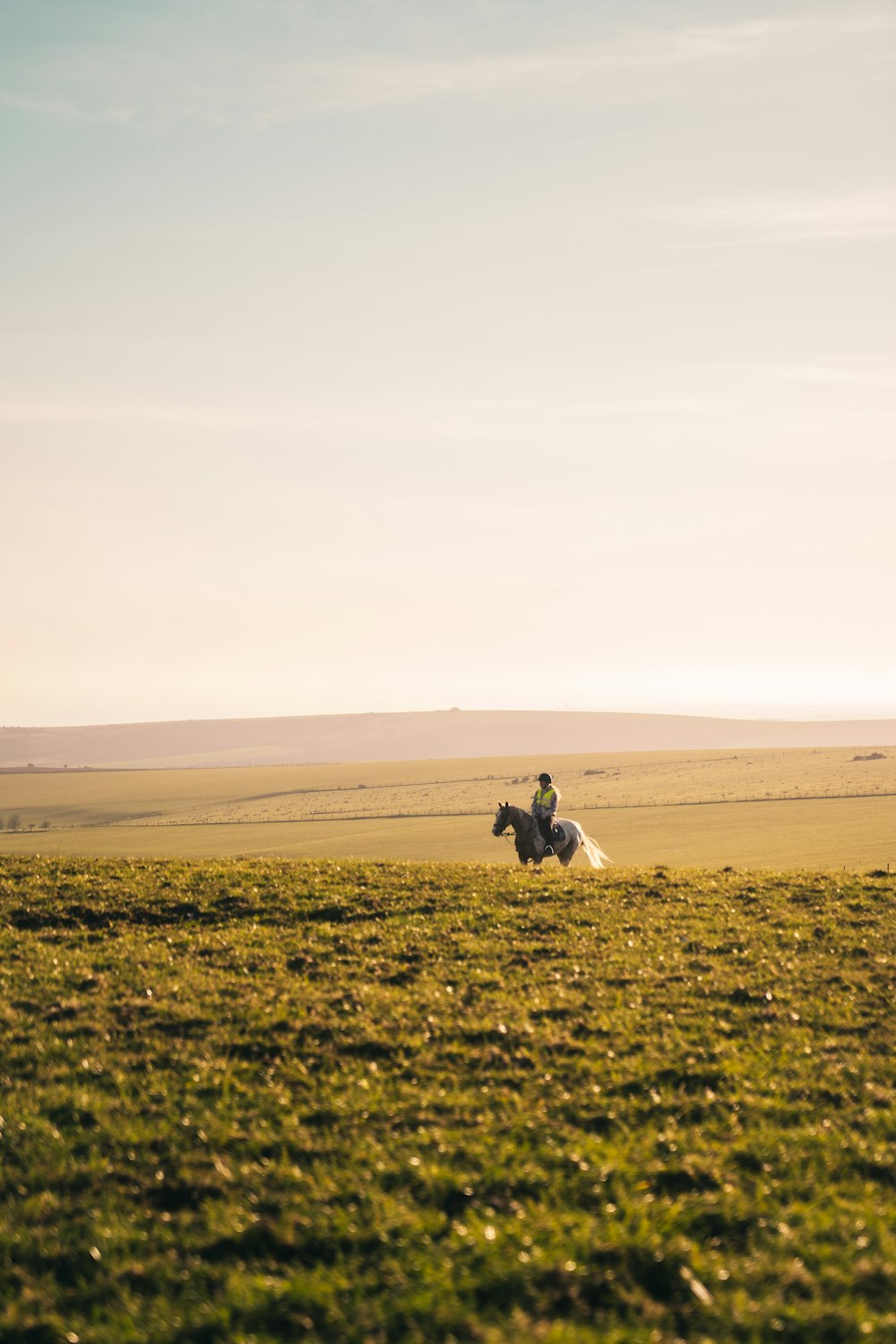 man in white shirt and black pants sitting on green grass field during daytime