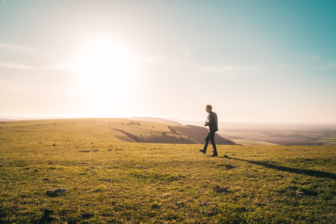 man in black jacket standing on green grass field during daytime