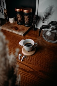 white ceramic mug on brown wooden table