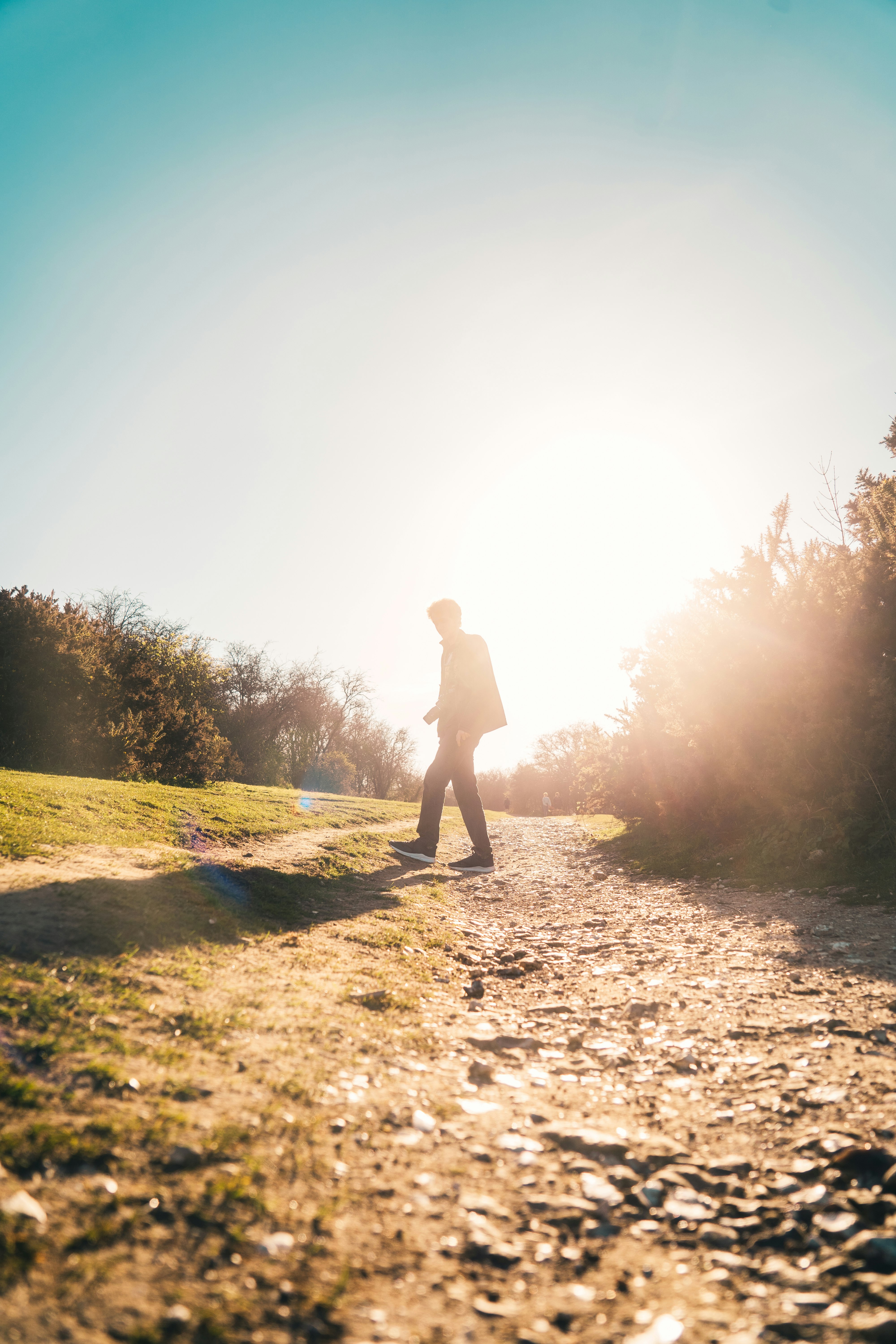 woman in black dress standing on brown dirt road during daytime