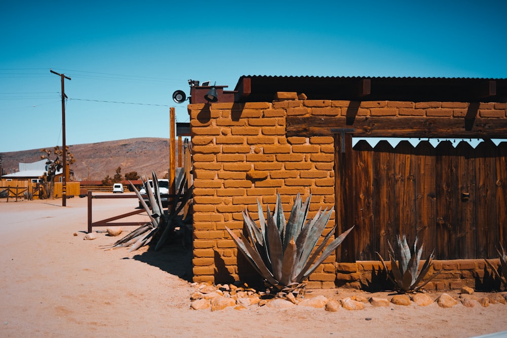 brown wooden fence on brown sand during daytime