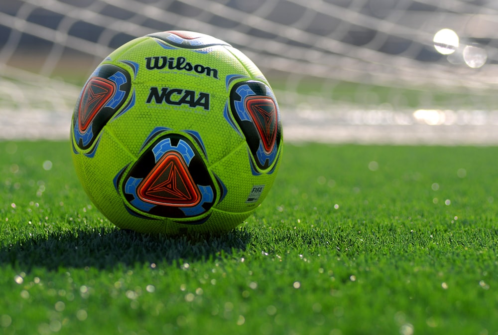 white green and blue soccer ball on green grass field during daytime