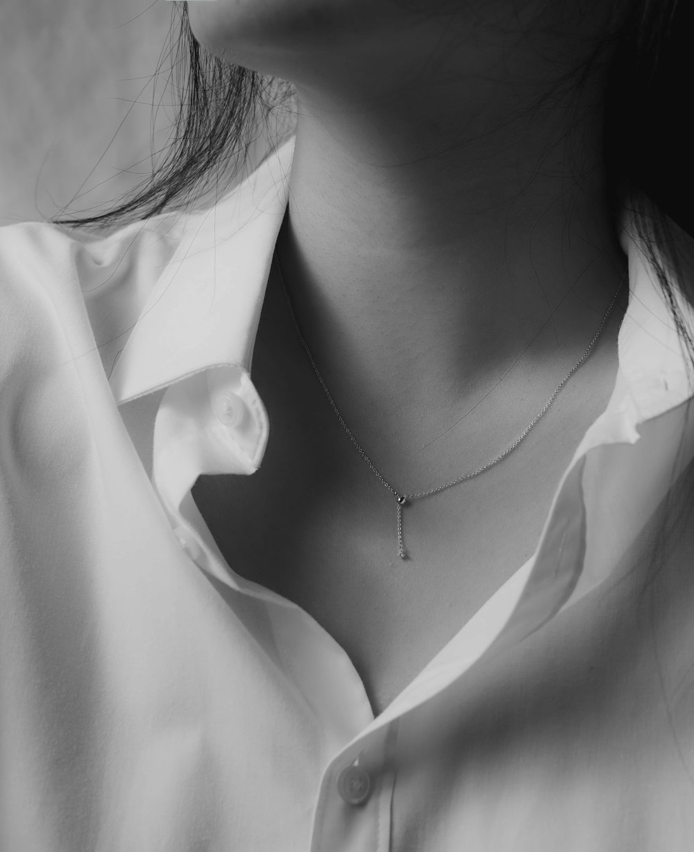 grayscale photo of woman wearing silver necklace