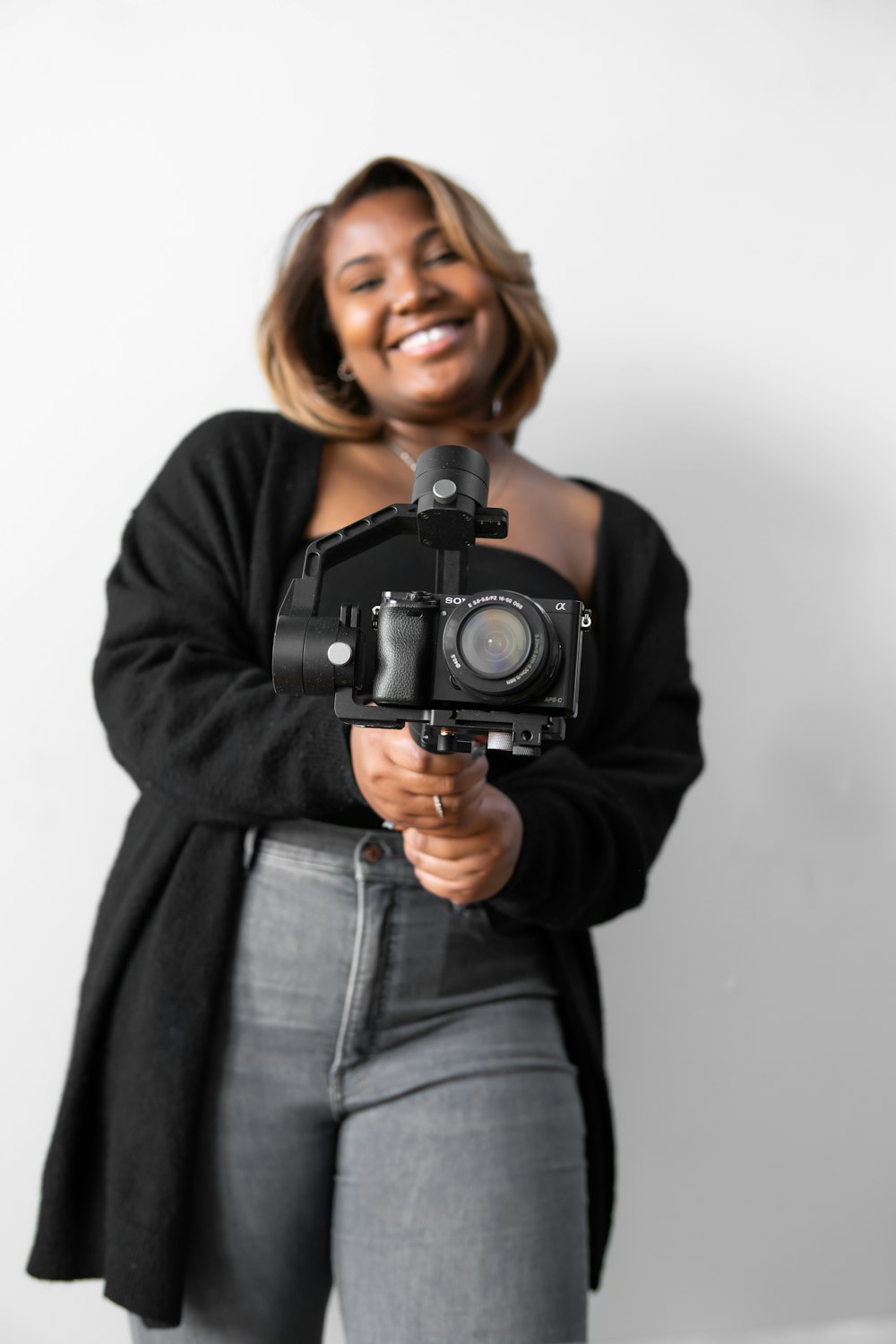woman in black jacket holding black dslr camera