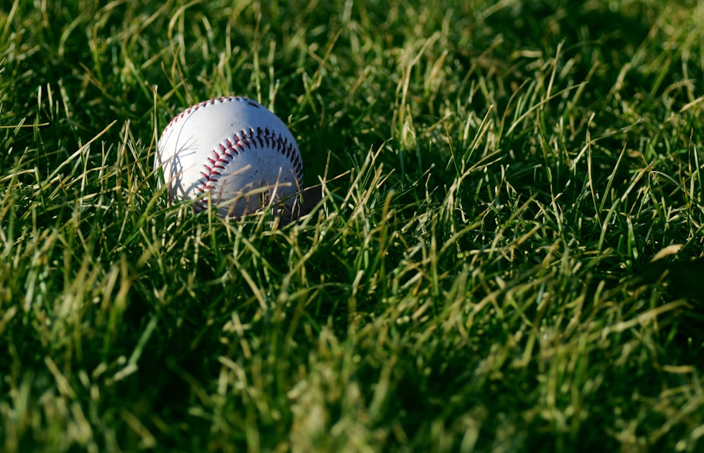 white baseball on green grass during daytime