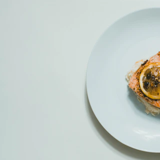 A fresh, simple one-pan salmon dinner garnished with lemon and herbs.