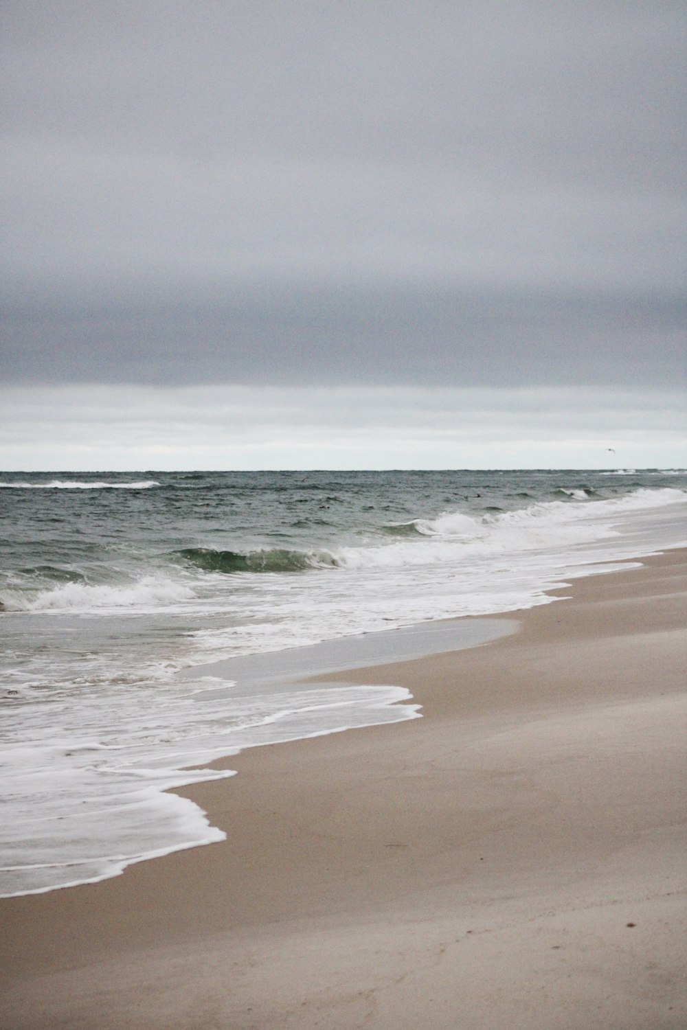 ocean waves crashing on shore during daytime