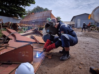 A team of welders working on a construction site with safety gear.