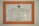 A framed plaque with a beige marble pattern background and a bold orange border featuring Indonesian text. The plaque is a commemoration from Yayasan Amalbakti Muslim Pancasila, dated June 14, 1996, and includes a signature at the bottom.