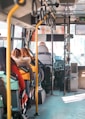 woman in orange jacket sitting on bus seat
