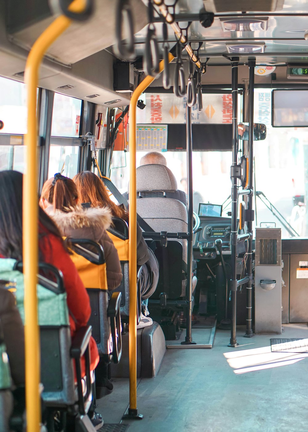 woman in orange jacket sitting on bus seat