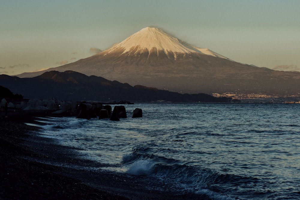 日中の水域近くの茶色の山