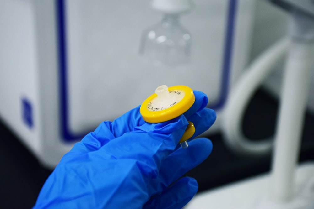 person in blue long sleeve shirt holding yellow and white plastic toy