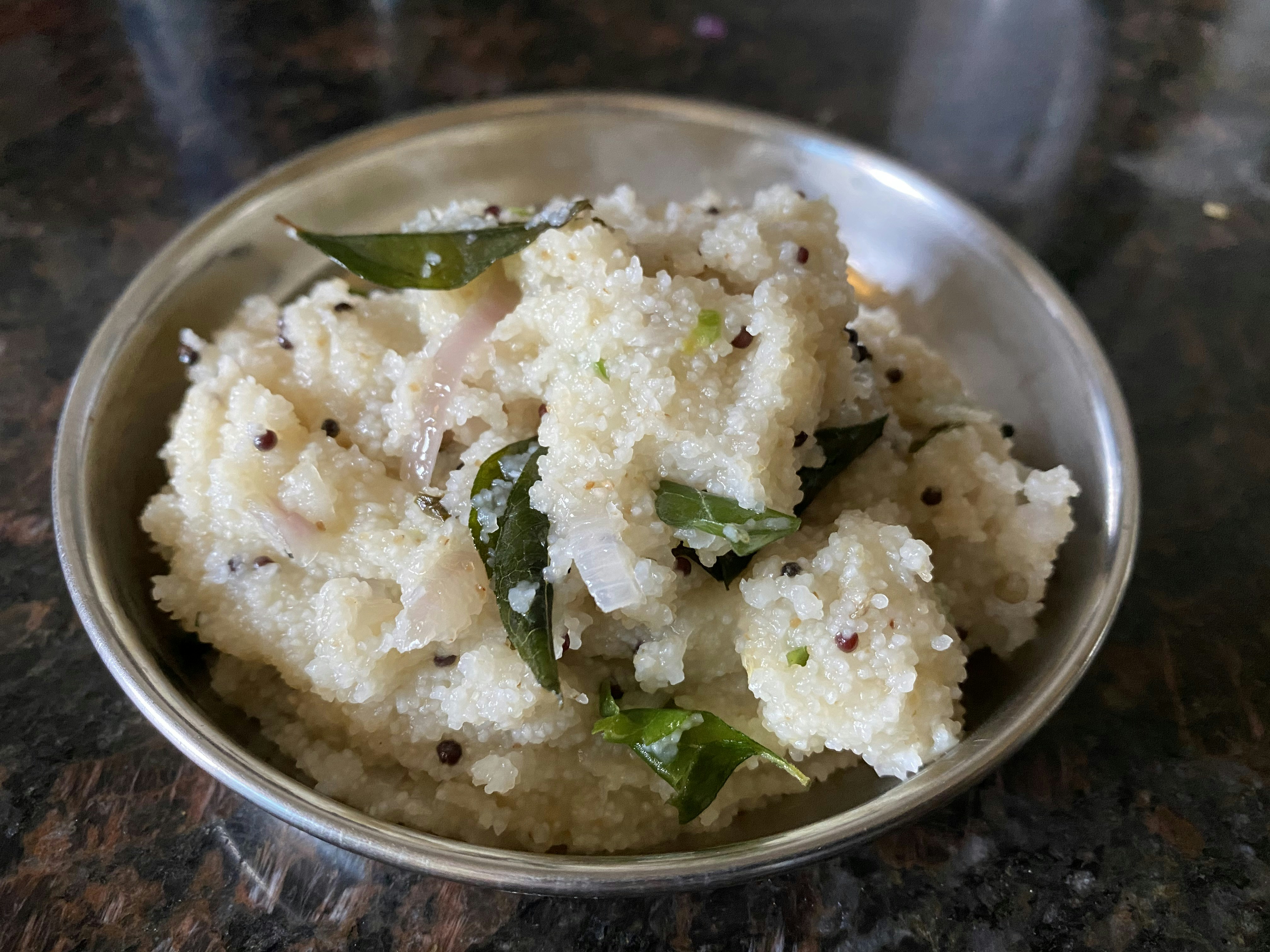 Upma semolina porridge with vegetables in traditional brass bowl