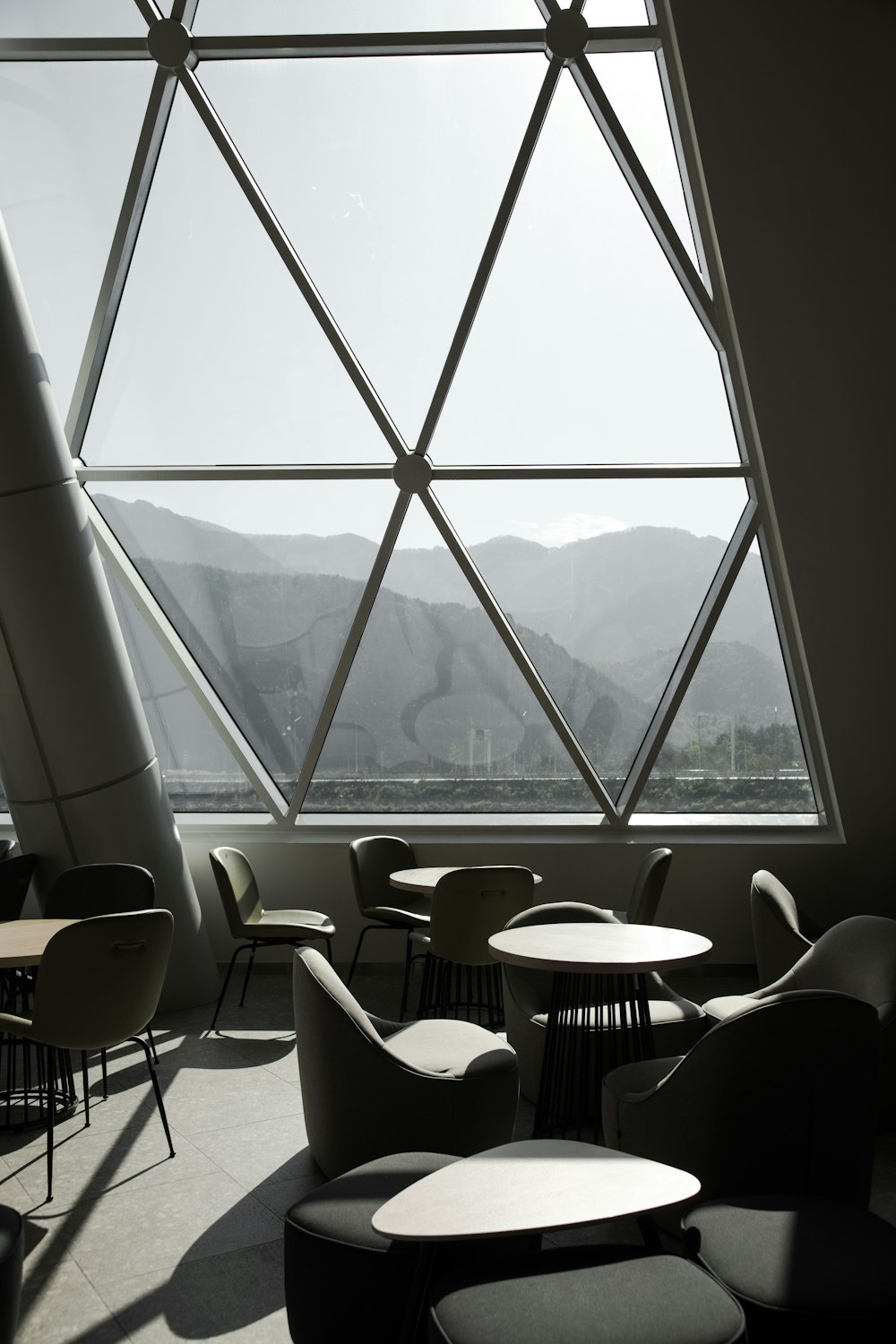 white and black chairs near window