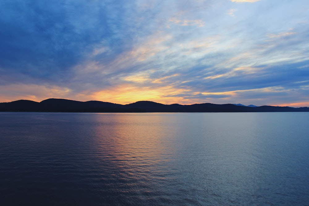 body of water under cloudy sky during daytime