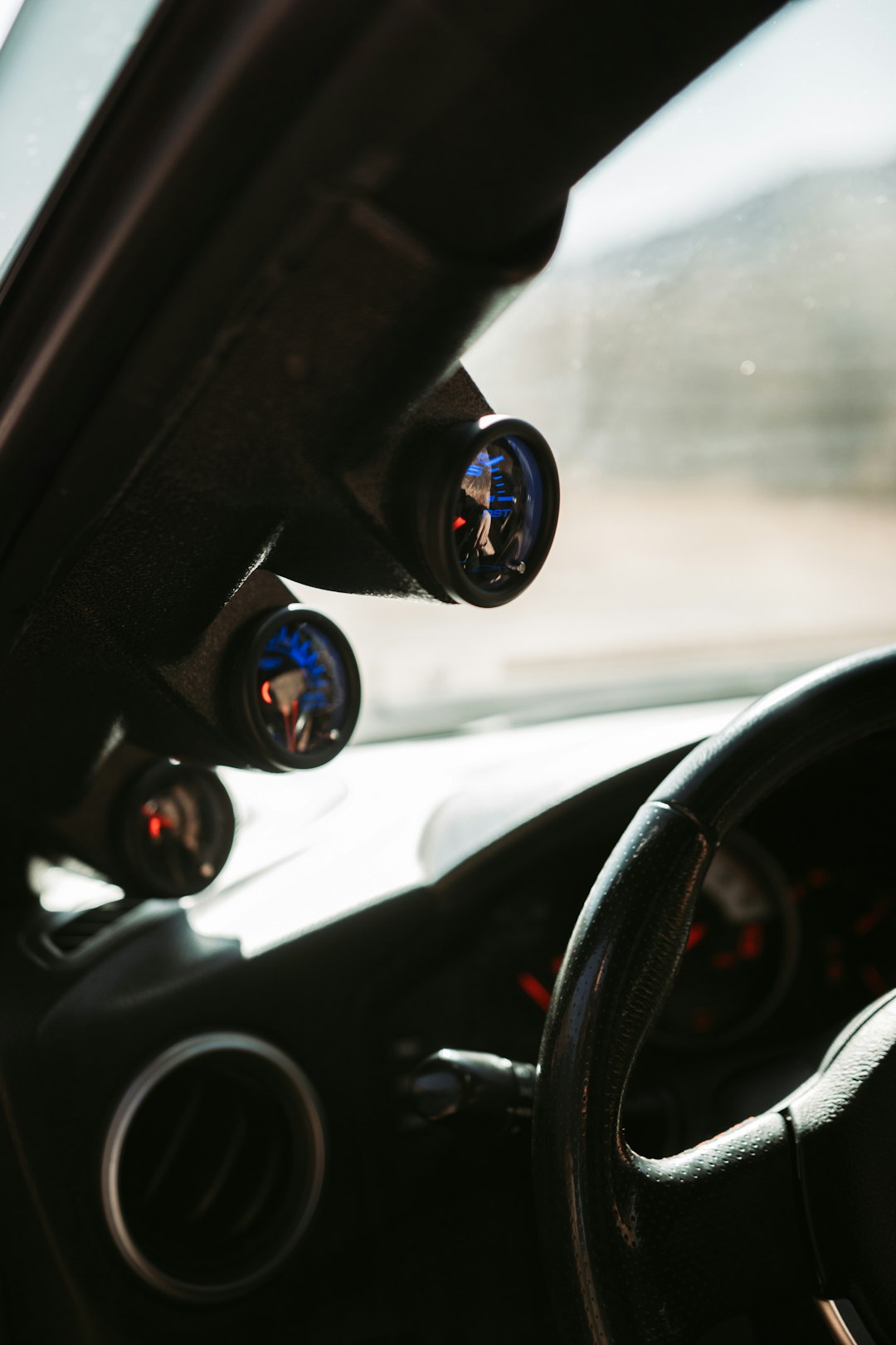 black car steering wheel with water droplets